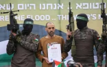 Des combattants du Hamas escortent l'otage israélien Or Levy sur un podium avant de le remettre à une équipe de la Croix-Rouge à Deir el-Balah, dans le centre de Gaza, le 8 février 2025
