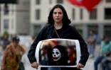 Cynthia Aboujaoude, une manifestante libanaise, tient une photo d'elle grimée en Joker, à Beyrouth le 23 octobre 2019.
