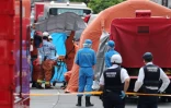 Policiers et secouristes travaillent sur le lieu de l'attaque au couteau de Kawasaki, dans la banlieue sud de Tokyo, le 28 mai 2019
