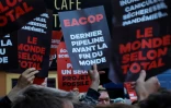 Des manifestants pour le climat aux abords de la salle parisienne où doit se dérouler l'assemblée générale annuelle de TotalEnergies, le 26 mai 2023, à Paris