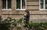 Un homme frappe à une fenêtre le 2 mai 2022 à Lyman, dans l'est de l'Ukraine, pour livrer du pain aux résidents restés dans cette ville malgré l'offensive des troupes russes