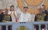 Photo fournie le 26 avril 2022 par l'agence nord-coréenne Kcna du dirigeant nord-coréen Kim Jong Un (c) assistant à une parade militaire à Pyongyang, le 25 avril 2022