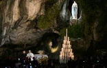 Le pape Léon XIV préside une prière avec des fidèles aux côtés de l'archevêque italien Diego Ravelli (à gauche) à la grotte de Massabielle, dans le sanctuaire de Notre-Dame de Lourdes, le 26 septembre 2026