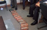 L'aristocrate britannique, Jack Alexander Wolf Marrian (D), face aux 100 kilos de cocaïne, le 11 novembre 2016 au siège du Département d'enquête criminelle de Nairobi