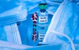 Photo d'une figurine du père Noël près d'une fiole indiquant "Vaccine Covid-19" parmi des masques chirurgicaux, prise à Paris le 17 décembre 2020