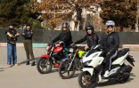 La monitrice Maryam Ghelich (g) et ses élèves Narghes (d), Elham (3e d), Leila et Mona lors d'un cours de conduite de moto dans un cente d'entraînement du nord de Téhéran, le 7 décembre 2025 en Iran