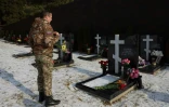 Iouri, employé dans une école privée, qui a participé à l'action militaire russe en Ukraine en tant qu'opérateur radio, se recueille devant les tombes de soldats tués sur le front, le 7 février 2025 à Istra, dans la région de Moscou