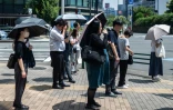 Les gens portent des parapluies pour se protéger du soleil à Tokyo le 23 juillet 2026
