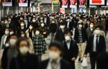 Des personnes portant un masque de protection se rendent sur leurx lieux de travail, le 16 avril 2020 à Tokyo