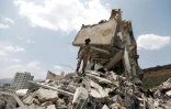 Un yéménite sur les décombres d'une maison détruite par des frappes aériennes le 26 août 2017, dans un quartier résidentiel de Sanaa