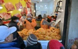 Des habitants font la queue tôt le matin pour acheter du poulet à prix de gros, le 11 juin 2025 à La Paz, en Bolivie