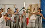 L'actrice grecque Mary Mina transmet la flamme olympique au premier relayeur pour les Jeux d'hiver 2026 de Milan-Cortina, le Grec Petros Gaidatzis, lors d'une cérémonie au Musée antique d'Olympie, en Grèce, le 26 novembre 2025