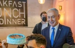 Le Premier ministre israélien Benjamin Netanyahu (d) échange avec des sympathisants venus lui offrir un gâteau pour son 77e anniversaire, lors d’une rencontre dans un café à Dimona, le 21 octobre 2026 en Israël