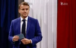 Le président Emmanuel Macron quitte l'isoloir dans un bureau de vote lors du 1er tour des législatives, le 30 juin 2024 au Touquet, dans le Pas-de-Calais