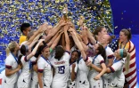 L'équipe de football féminine américaine brandit la Coupe du monde qu'elle vient de remporter, près de Lyon (France) le 7 juillet 2019