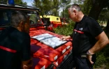 Des pompiers regardent une carte du département des Bouches-du-Rhône à Marseille, à Gardanne dans le sud de la France le 25 juillet 2023, alors que le département était en "alerte rouge", un risque élevé d'incendies de forêt.