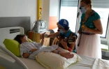 Des clowns de l'association "Le Rire Medecin" avec une enfant malade le 25 juillet 2016 à l'hôpital Necker à Paris