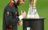Le gardien de but de Manchester United, David de Gea, passe devant le trophée de la Ligue Europa après avoir reçu sa médaille d’argent à l'issue de la finale contre Villarreal, à Gdansk, le 26 mai 2021