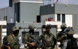 Des soldats israéliens devant l'entrée d'une maison palestinienne assiégée par des colons israéliens dans le village de Qusra, au sud de Naplouse, en Cisjordanie occupée, le 14 août 2026