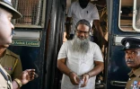 Des policiers escortent les accusés impliqués dans les attentats de Pâques 2019, lors du prononcé du verdict à la Haute Cour de Colombo, le 22 septembre 2026 au Sri Lanka