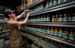 Tim Gyger range des bouteilles d'eaux-de-vie à base de racines de gentiane dans la distillerie Gagygnole, le 10 mai 2022 à Souboz, en Suisse