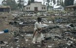 Une jeune fille déplacée marche au milieu des débris dans un camp déserté par sa population, à Goma le 2 février 2025