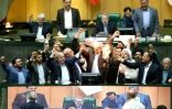 Photo distribuée par le Parlement iranien montrant des députés en train de brûler un drapeau américain en papier, le 9 mai 2018 à Téhéran