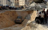 Des Palestiniens regardent une pelleteuse creuser dans le sol à la recherche apparemment de corps à Khan Younès, dans le sud de la bande de Gaza, le 17 octobre 2025