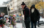 Le chanteur et le guitariste du groupe américain Eagles of Death metal Jesse Hughes et Dave Catching rendent hommage le 8 décembre 2015 aux victimes des attentats de Paris devant le mémorial improvisé devant le Bataclan