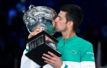 Le Serbe Novak Djokovic embrasse le trophée de l'Open d'Australie, après sa victoire en finale, le 21 février 2021 à Melbourne