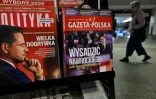 Une femme traverse un passage souterrain devant un kiosque vendant des magazines dont les Unes montrent les candidats à la présidentielle polonaise de 2025, Rafal Trzaskowski (g) et Karol Nawrocki (d), à Varsovie, le 19 mai 2025