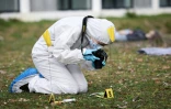 Une étudianes de l'école CY Forensic prend des photos sur la reconstitution d'une scène de crime lors d'une session de formation à Neuville-sur-Oise, au nord-est de Paris, le 21 mars 2025 dans le Val d'Oise