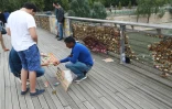 Un vendeur de cadenas sur la passerelle Léopold-Sedar-Senghor, à Paris le 4 août 2016
