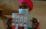 Une femme montre un bulletin de vote pour la présidentielle, le 31 octobre 2020 à Abobo, un quartier populaire d'Abidjan, en Côte d'Ivoire