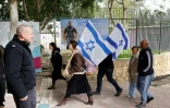 Des personnes portant des drapeaux israéliens se dirigent vers les funérailles de l'otage Ran Gvili, à Meitar, le 28 janvier 2026