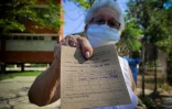 Une femme montre sa carte de vaccination après avoir reçu une injection du candidat-vaccin cubain Abdala contre le Covid-19, le 12 mai 2021 à La Havane