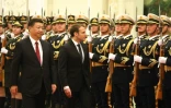 Le président Emmanuel Macron et son homologue chinois Xi Jinping (g) passent en revue la garde d'honneur, au Palais du Peuple, le 9 janvier 2018 à Pékin