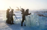 Des villageois en Iakoutie (nord-est de la Sibérie) extraient un bloc de glace qui les approvisionnera en eau douce pour l'hiver, le 27 novembre 2018 à Oï en Russie
