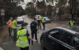 Des gendarmes filtrent des véhicules sur une route menant à la commune de Le Porge, en Gironde, ravagée par un incendie, le 31 juillet 2026 