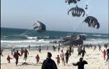 Capture d'écran d'une vidéo AFPTV de Palestiniens qui courent direction de parachutes transportant des colis de nourriture larguée par des avions américains sur une plage de la bande de Gaza le 2 mars 2024