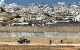 Des soldats de l'armée israélienne marchent vers un véhicule blindé à un poste situé dans le sud d'Israël le long de la barrière avec la bande de Gaza dévastée par la guerre, le 30 septembre 2025