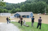Une famille regarde sa maison inondée par des pluies torrentielles à Jackson, le 28 juillet 2022 dans le Kentucky