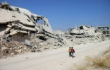 Des enfants marchent parmi les ruines dans un quartier rebelle de la ville de Deraa, le 17 septembre 2017