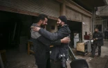 Le photographe syrien Sameer al-Doumy (d) retrouve un ami dans son ancien quartier à Douma, près de Damas, le 22 décembre 2024