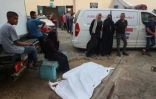 Des Palestiniens encerclent le corps d'une personne tuée par une frappe dans la cour d'un hôpital à Deir el-Balah, dans le centre de la bande de Gaza, le 20 juillet 2024