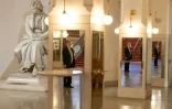 Dans l'entrée du Konzerthaus avant un concert, un employé, le visage protégé pour lutter contre le coronavirus, attend près d'une statue du compositeur Ludwig van Beethoven, le 6 juin 2020 à Vienne