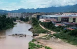 Barge traversant la rivière frontalière Moei au niveau du complexe KK Park à Myawaddy en Birmanie (à droite), photographiée depuis Mae Sot en Thaïlande, le 17 septembre 2025
