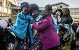 Mary Kangongo (c), la mère du marathonien kényan Kelvin Kiptum, suivie de l'épouse de l'athlète Asenath Rotich, soutenues par des proches, avant la procession du cercueil dans les rues d'Eldoret, le 22 février 2024