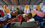 Des équipes de secours prennent en charge des blessés dans un hôpital de fortune, le 6 août 2018 à Mataram, après un séisme meurtrier sur l'île de Lombok, en Indonésie