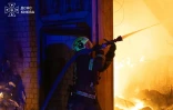 Photo prise et diffusée le 8 août 2026 par le service d’État ukrainien des situations d’urgence montrant un pompier luttant contre un incendie après des frappes de missiles balistiques russes à Kiev